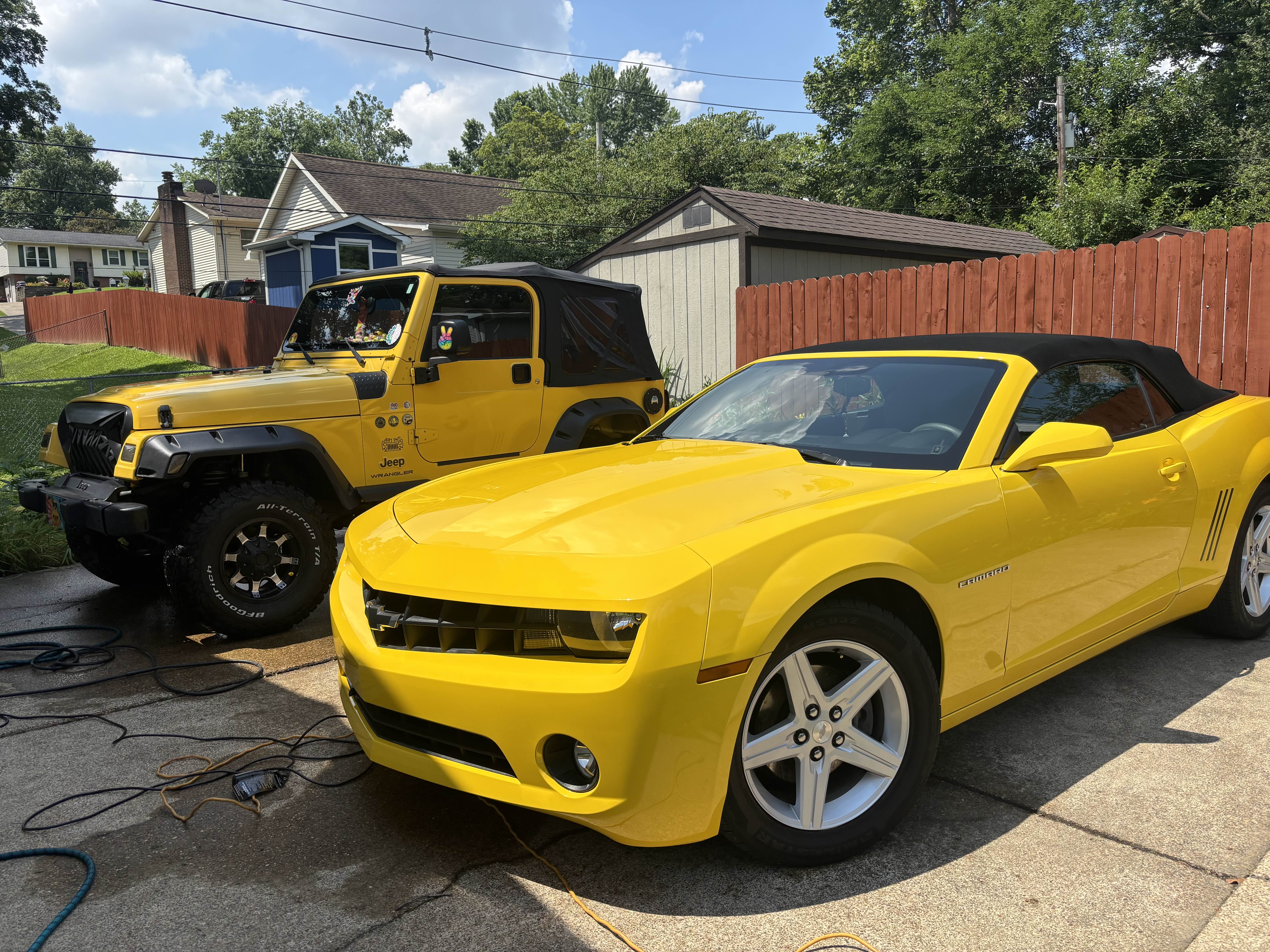 Yellow Jeep Wrangler and Chevrolet Camaro after detailing